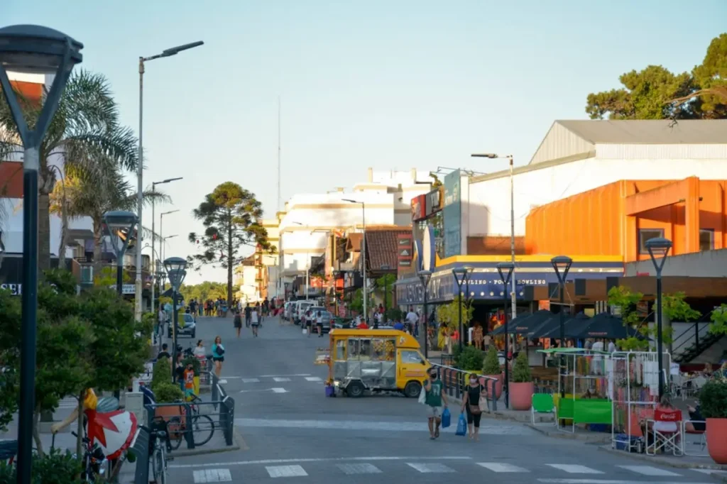 Avenida principal de Villa Gesell con locales comerciales y turistas caminando